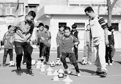 兰州市七里河小学体育教师给孩子们上足球课(