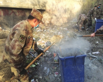驻兰某工程维护大队官兵帮驻地居民清理街道垃圾