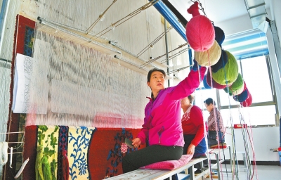 张掖肃南县华鑫民族地毯厂工人们正在编织地毯（图）