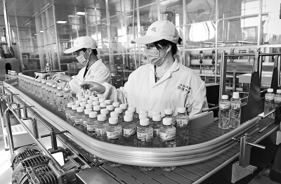 工人在临夏永靖县浩通纯净水罐装生产线上作业（图）