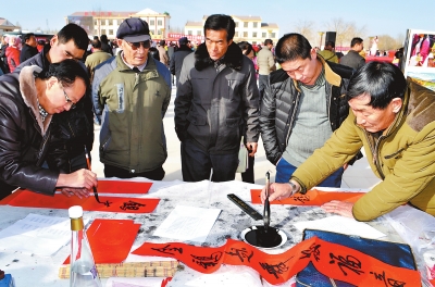 张掖市委宣传部组织书法家在肃南县农村为群众写春联（图）