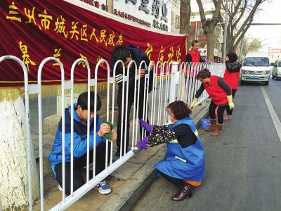 兰州皋兰路街道王家庄社区人员给沿街护栏“洗脸”（图）