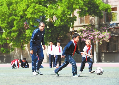 兰州市东郊学校的西班牙外教拉法给学生上足球课（图）