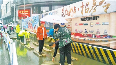 兰州城关交警大队民警在积水处临时搭建栅道供市民通行（图）