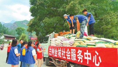 志愿者在文县天池镇王家庄村安置点给受灾群众发放物资