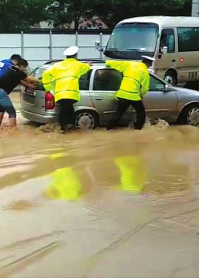 兰州突遇降雨轿车水中熄火 交警市民齐力推车保畅通 