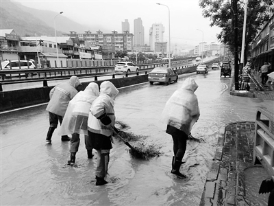 冒着大雨 兰州市政人员打开井盖排水