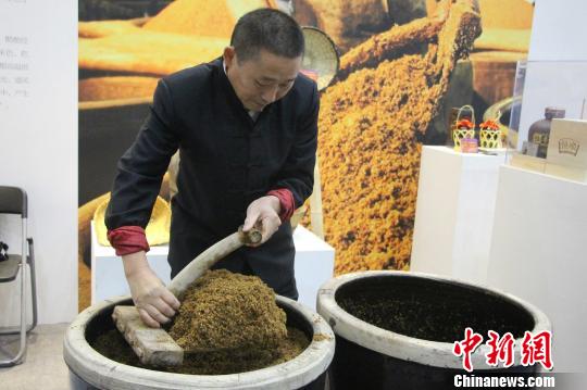 镇江恒顺香醋酿造技艺国家级代表性传承人乔贵清在现场向参观者展示酿