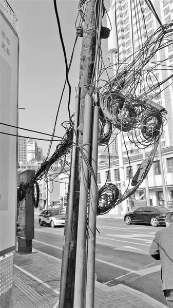 兰州七里河区敦煌路什字人行道上一处电缆线混乱低垂 存安全隐患