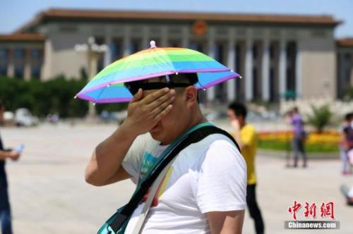 游客在高温下擦汗。<a target='_blank' data-cke-saved-href='http://www.chinanews.com/' href='http://www.chinanews.com/'>中新社</a>发 李慧思 摄 点击进入下一页
