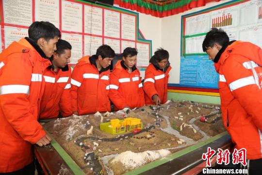 图为近日，阿里地区公路养护段护路工人在看工区道路的沙盘图。　阿旺扎西 摄