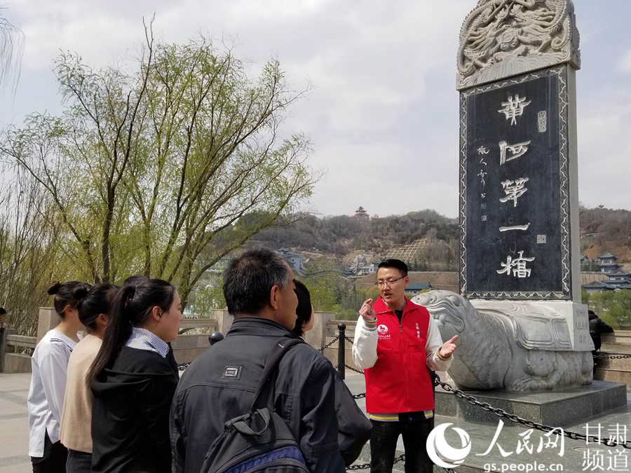 一位志愿者正在为游客讲解中山桥的历史。（黄帆 摄）