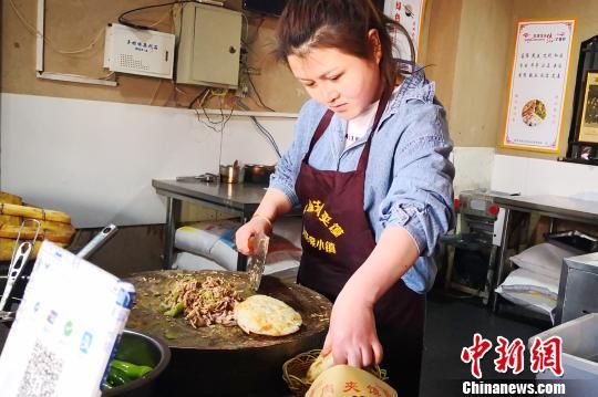 图为张莎在月牙泉小镇做陕西潼关肉夹馍。(资料图) 南如卓玛 摄 图为张莎在月牙泉小镇做陕西潼关肉夹馍。(资料图) 南如卓玛 摄