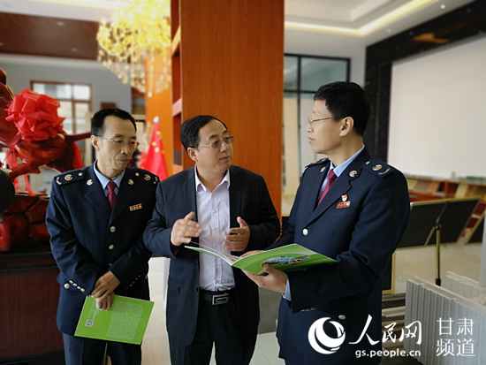 庆阳市税务局工作人员向当地企业负责人宣传减税降费政策。（黄帆 摄）