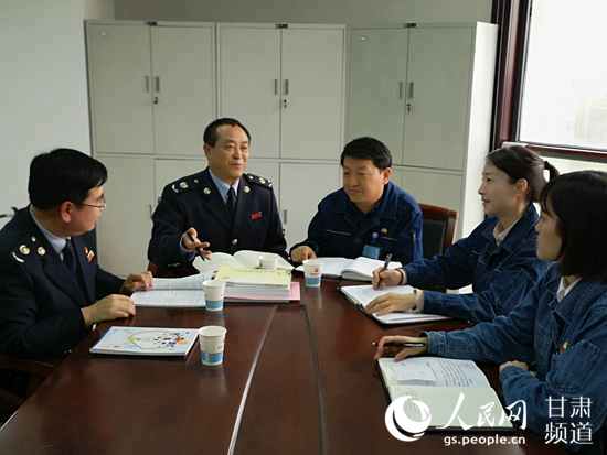 庆阳市税务局工作人员在庆阳石化向企业员工宣传减税降费政策。（黄帆 摄）