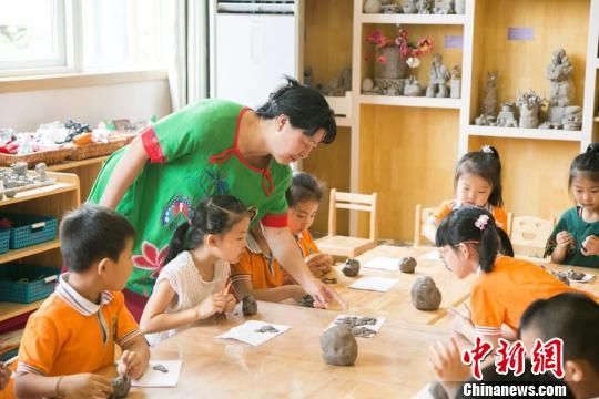 图为刘雪玲正在给幼教中心的孩子上泥塑课。 钟欣 摄 图为刘雪玲正在给幼教中心的孩子上泥塑课。 钟欣 摄