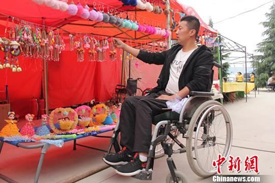 庆阳西峰区温泉镇地庄村身体残疾的李华宁携带手工艺品参加节会。 刘萍凝 摄 庆阳西峰区温泉镇地庄村身体残疾的李华宁携带手工艺品参加节会。 刘萍凝 摄