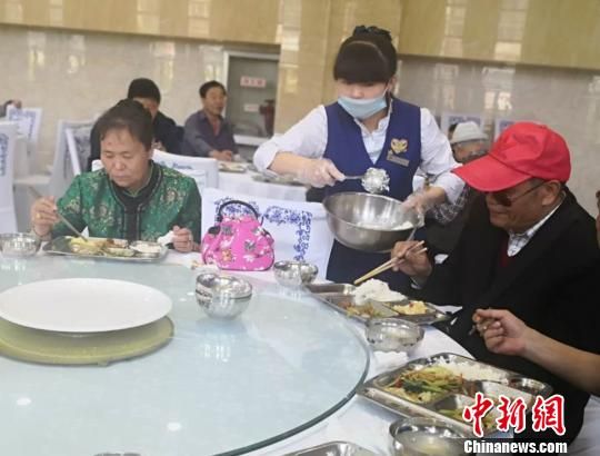 图为兰州市一家“养老餐厅”的服务员为就餐的老人添菜。 史静静 摄 图为兰州市一家“养老餐厅”的服务员为就餐的老人添菜。 史静静 摄