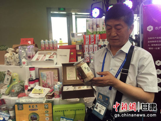 图为兰州一农业科技公司总经理梁建民手拿瓶装藜麦向驻足于展台前的客商们介绍产品。 图为兰州一农业科技公司总经理梁建民手拿瓶装藜麦向驻足于展台前的客商们介绍产品。