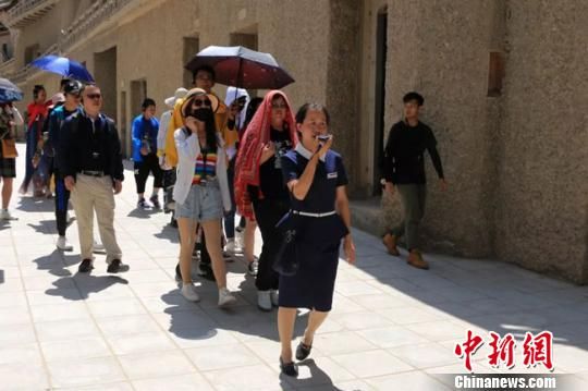 图为敦煌莫高窟志愿者讲解员正在带领游客参观。 敦煌研究院供图 摄 图为敦煌莫高窟志愿者讲解员正在带领游客参观。 敦煌研究院供图 摄