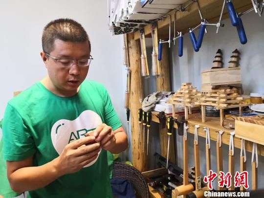 图为王跃天介绍家长和学生已经制作的作品。 高康迪 摄 图为王跃天介绍家长和学生已经制作的作品。 高康迪 摄