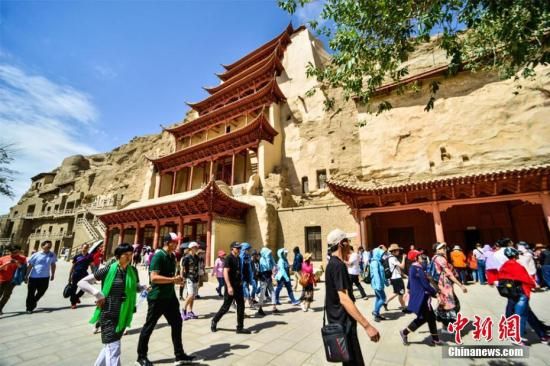 莫高窟标志性建筑“九层楼”前的游人如织。王斌银 摄 莫高窟标志性建筑“九层楼”前的游人如织。王斌银 摄