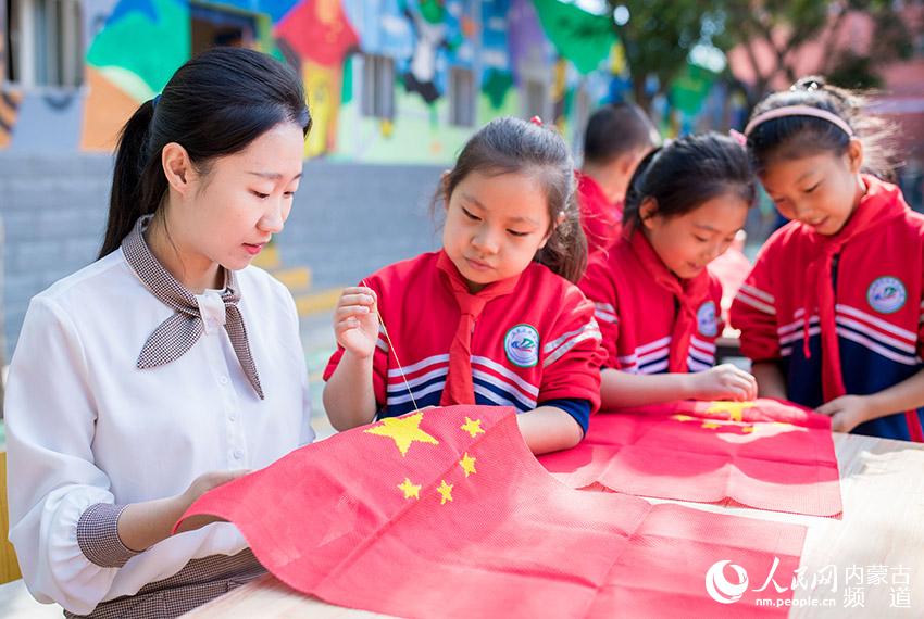 呼和浩特市玉泉区南茶坊小学师生以绣制国旗的方式庆祝新中国70华诞。