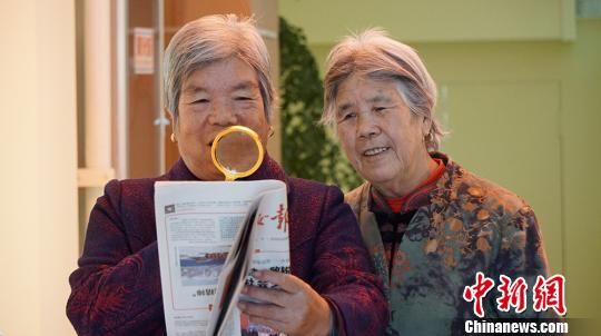图为社区居民从“便民服务柜”借放大镜看报纸。 魏建军 摄 图为社区居民从“便民服务柜”借放大镜看报纸。 魏建军 摄
