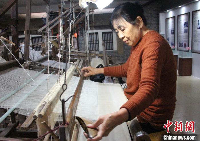 图为工人在使用手工木织机加工传统柳疃丝绸。 赵晓 摄 图为工人在使用手工木织机加工传统柳疃丝绸。 赵晓 摄