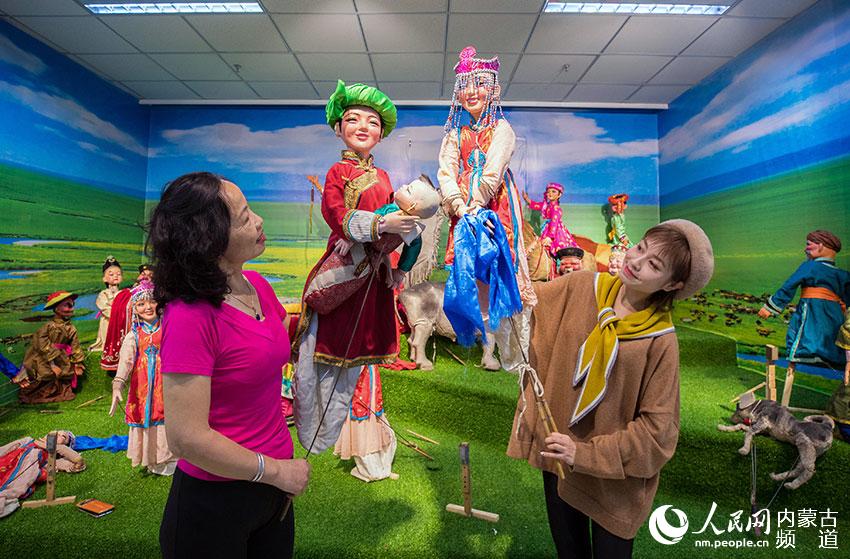 文艺骨干在呼和浩特市玉泉区文化馆学习木偶戏的表演技艺。
