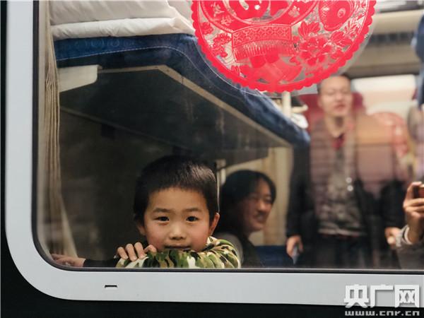 1月10日,在春运首趟增开的北京—南通K4051次列车上,一位小乘客透过车窗向外张望(央广网记者 王晶 摄)