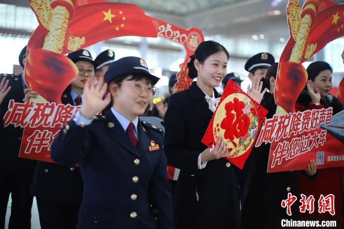 税收宣传志愿者在给旅客送上新年祝福的同时，还为他们宣传、讲解最新的国家普惠性税收政策。　泱波 摄