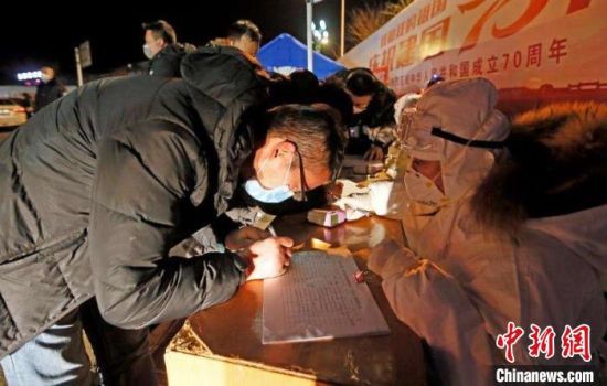 图为甘肃陇南市武都区医疗、公安人员深夜检测、登记出入车辆。　冉创昌 摄