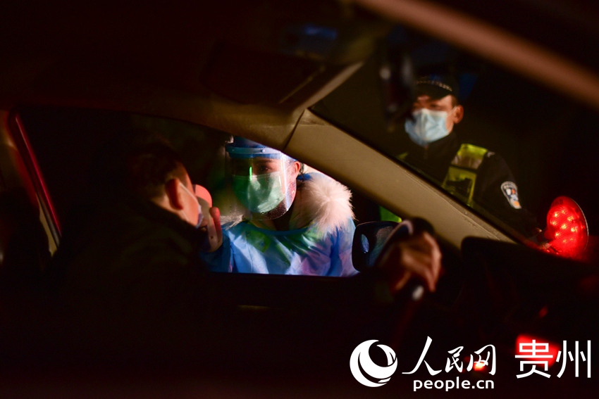 工作人员对司乘人员进行体温测量。