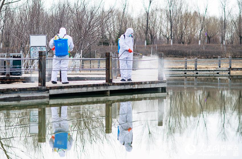 呼和浩特市湿地公园工作人员对游园环境进行消毒。