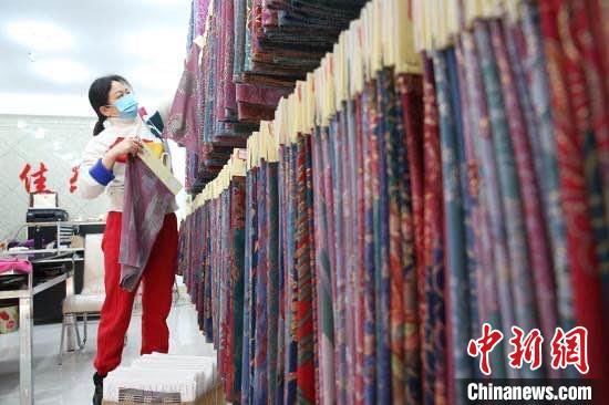 资料图:浙江中国轻纺城经营户整理面料。赵炜 摄 资料图:浙江中国轻纺城经营户整理面料。赵炜 摄