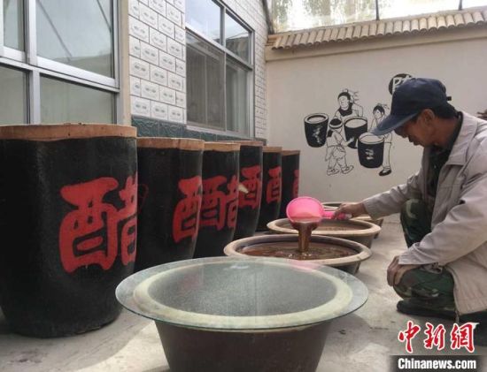 图为红旗村村民郭泰山在自家院子支摊开起手工醋坊。　张婧 摄