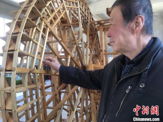 图为78岁的段怡村介绍黄河水车结构原理。　张婧 摄