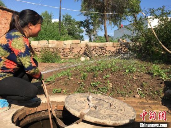 图为元古堆村村民用自来水管道给自家菜园浇水。 张婧 摄 图为元古堆村村民用自来水管道给自家菜园浇水。 张婧 摄