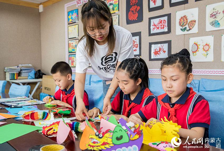 内蒙古自治区呼和浩特市玉泉区南茶坊小学学生在绘制“龙舟”。
