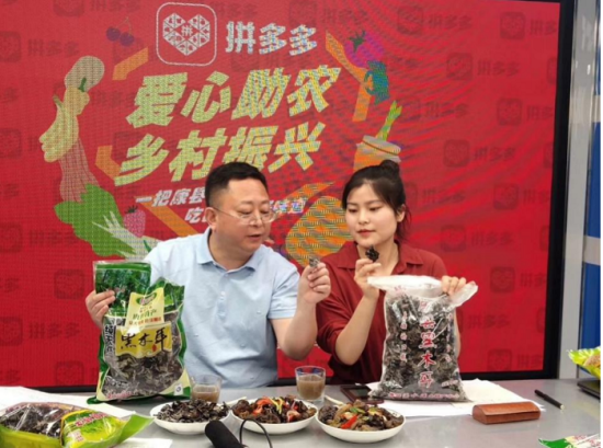 康县副县长张强(左)正在给镜头前的拼多多网友展示两种木耳的异同