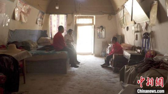 2018年5月，席宏涛(右一)和驻村队员闫军前往贫困户刘海峰家中讲异地扶贫搬迁政策。(资料图) 王琳 摄
