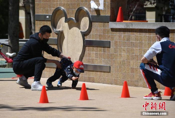 幼教机构教练在北京市朝阳区望京文化体育公园指导孩子锻炼。<a target='_blank' data-cke-saved-href='http://www.chinanews.com/' href='http://www.chinanews.com/'>中新社</a>记者 侯宇 摄 点击进入下一页