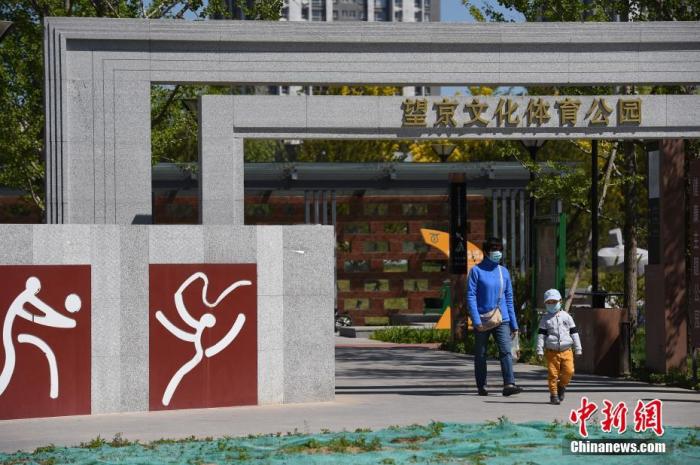 市民带着孩子经过北京市朝阳区望京文化体育公园。<a target='_blank' data-cke-saved-href='http://www.chinanews.com/' href='http://www.chinanews.com/'>中新社</a>记者 侯宇 摄 点击进入下一页