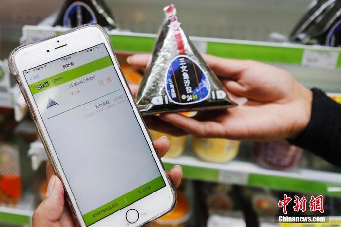 资料图:上海某自助便利店扫描商品条形码,使用手机自助结账后就直接可以离开。殷立勤 摄 资料图:上海某自助便利店扫描商品条形码,使用手机自助结账后就直接可以离开。殷立勤 摄