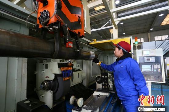 中国铁路兰州局集团有限公司兰州西车辆段轮轴装修工刘晓燕操控机床打磨轮轴。　　高展 摄