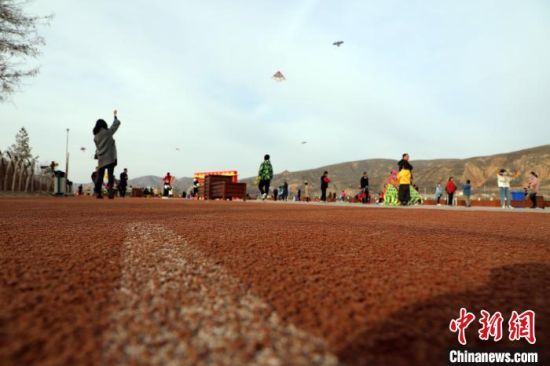 图为市民在智慧健身广场放风筝。 魏建军 摄 图为市民在智慧健身广场放风筝。 魏建军 摄