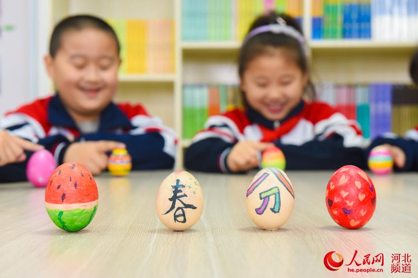 3月19日，河北邯郸市邯山区阳光实验小学学生在玩立蛋游戏。 李昊摄