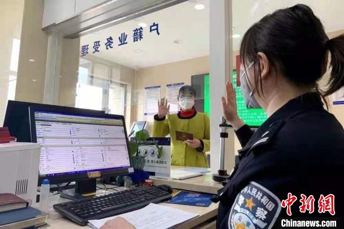 图为户籍窗口工作人员为外地迁入人员办证。(资料图)甘肃省公安厅供图