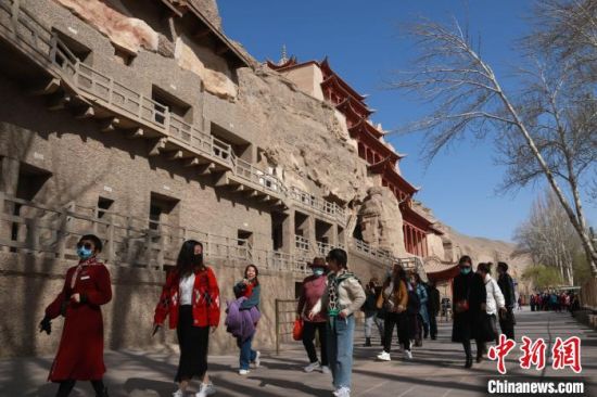 图为4月中旬,游客在敦煌莫高窟参观游玩。 张晓亮 摄 图为4月中旬,游客在敦煌莫高窟参观游玩。 张晓亮 摄